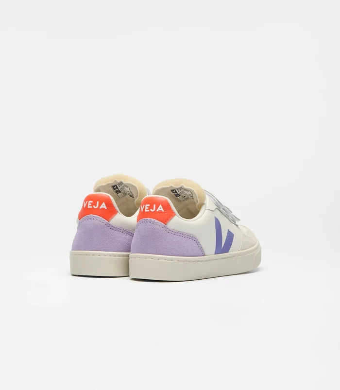 A pair of Veja low-top sneakers shown from the back, featuring a white canvas upper, light purple suede heel panels, a bright orange-red heel tab with white 'VEJA' branding, and a purple V logo on the side, set against a plain white background.