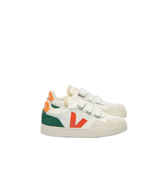 A pair of Veja sneakers in white leather and suede, featuring a green heel panel, orange accents on the heel tab and side logo, and three hook-and-loop strap closures.
