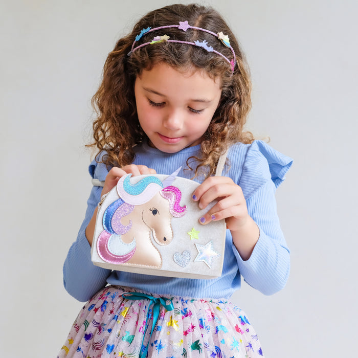 Young girl wearing unicorn purse