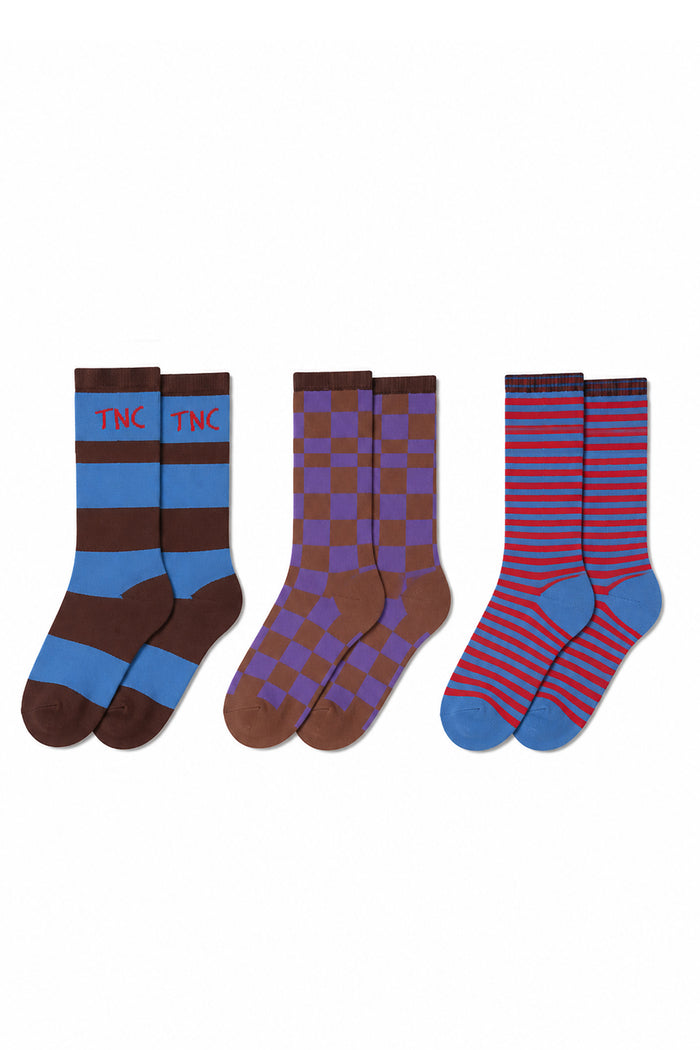 Three pairs of crew socks displayed side-by-side on a plain white background. The left pair is brown and light blue with 'TNC' in red on the cuff.