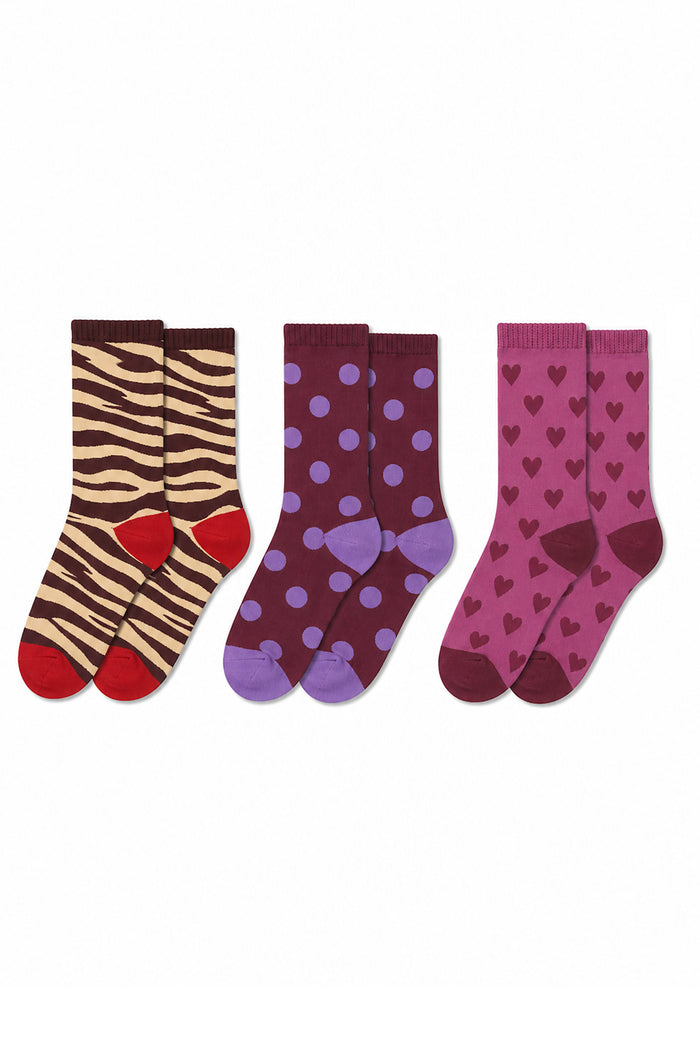 Three pairs of children's socks displayed side-by-side on a plain white background. The left pair features a brown and beige zebra print with red toes and heels.