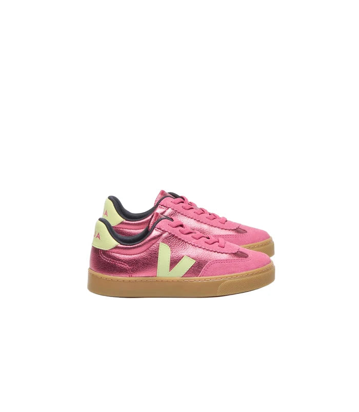 A pair of Veja sneakers in metallic pink with yellow-green accents and gum soles, photographed on a clean white background.