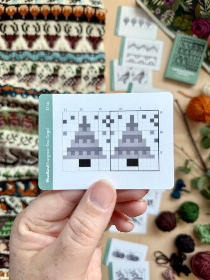 Hand holding a Woodland Doodle evergreen tree colorwork chart card