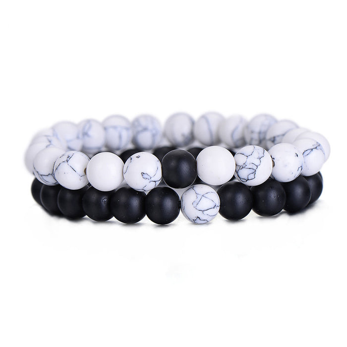 Two beaded stretch bracelets, one featuring white howlite with black marbling and the other in matte black onyx, shown as a pair on a white background.
